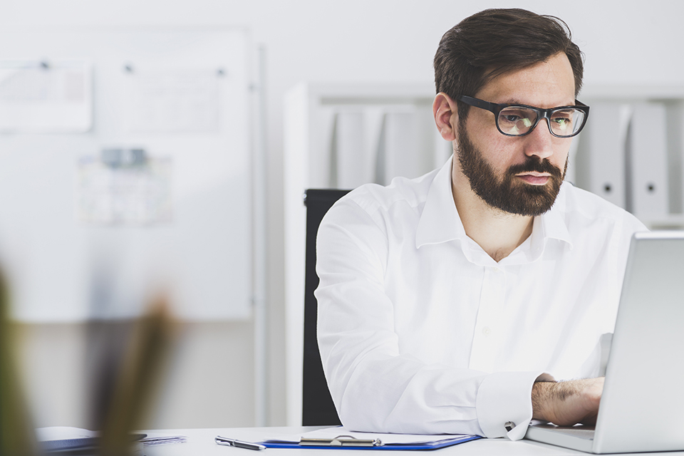 man using work laptop at clean office