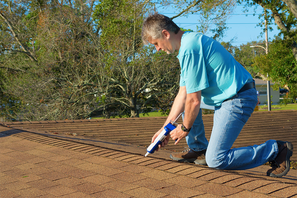 man fixing air leaks in roof